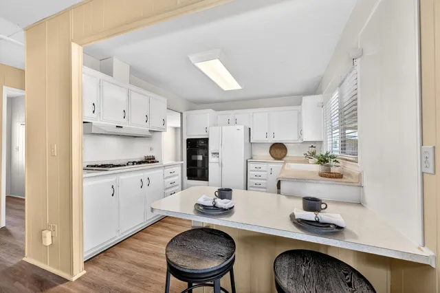 a kitchen with white cabinets and appliances
