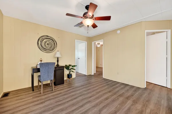 a view of room with wooden floor and ceiling fan