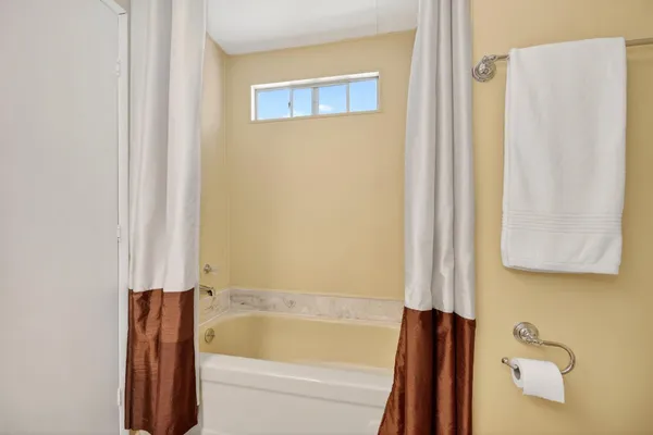 a bathroom with a tub and a shower curtain