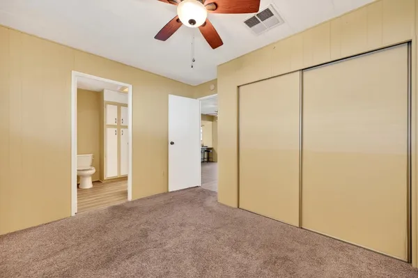 a view of a room with a ceiling fan and refrigerator