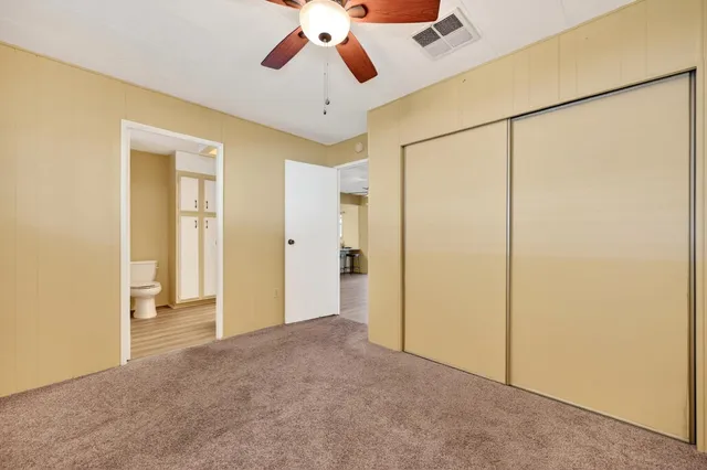 a view of a room with a ceiling fan and refrigerator