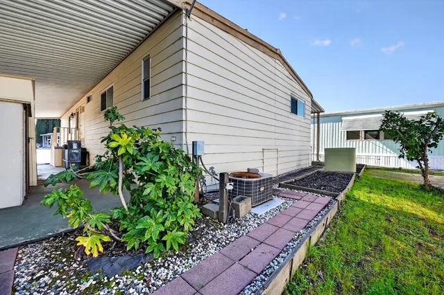 a front view of a house with a yard and potted plants