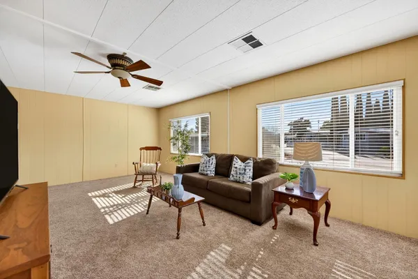 a living room with furniture a window and a flat screen tv
