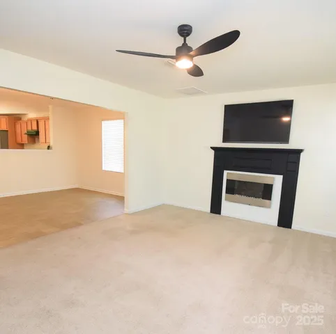 a view of an empty room with a fireplace and a window
