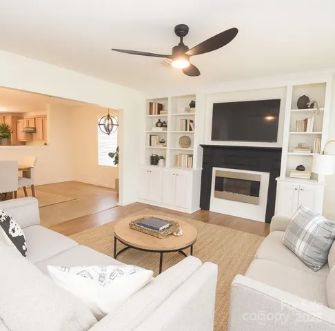 a living room with furniture a flat screen tv and a fireplace