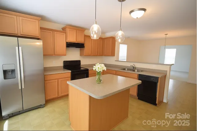 a kitchen with a sink a refrigerator a stove a microwave and island