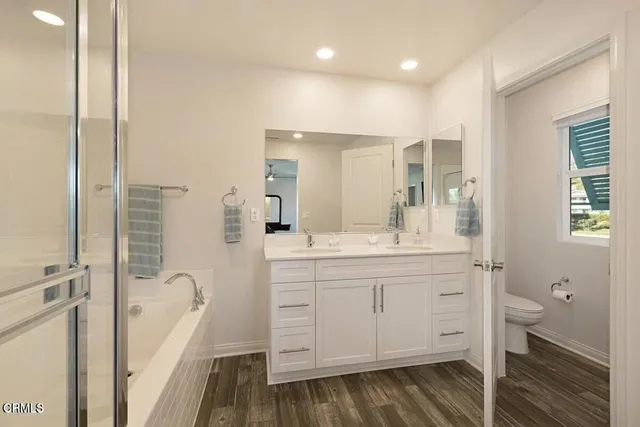 a bathroom with a bathtub sink vanity and mirror