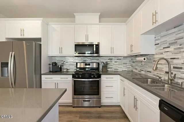 a kitchen with stainless steel appliances a stove sink microwave and cabinets