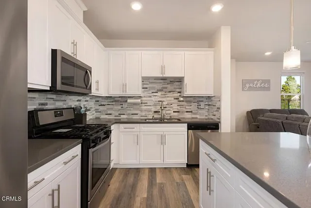 a kitchen with kitchen island a refrigerator stove microwave and cabinets