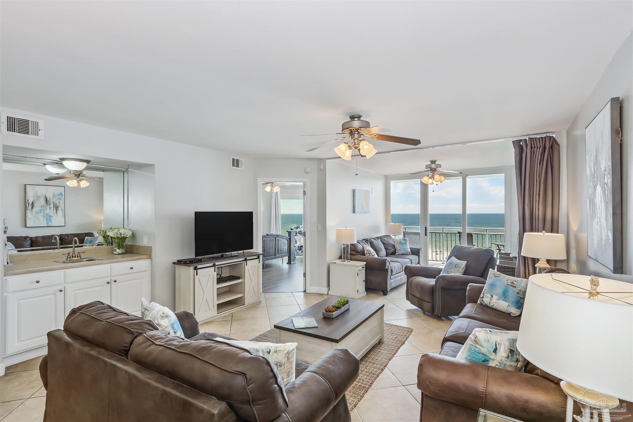 16285 Perdido Key Drive, Unit 424 Pensacola, FL 32507 - Photo 13 of 53 a living room with furniture a large window and a flat screen tv