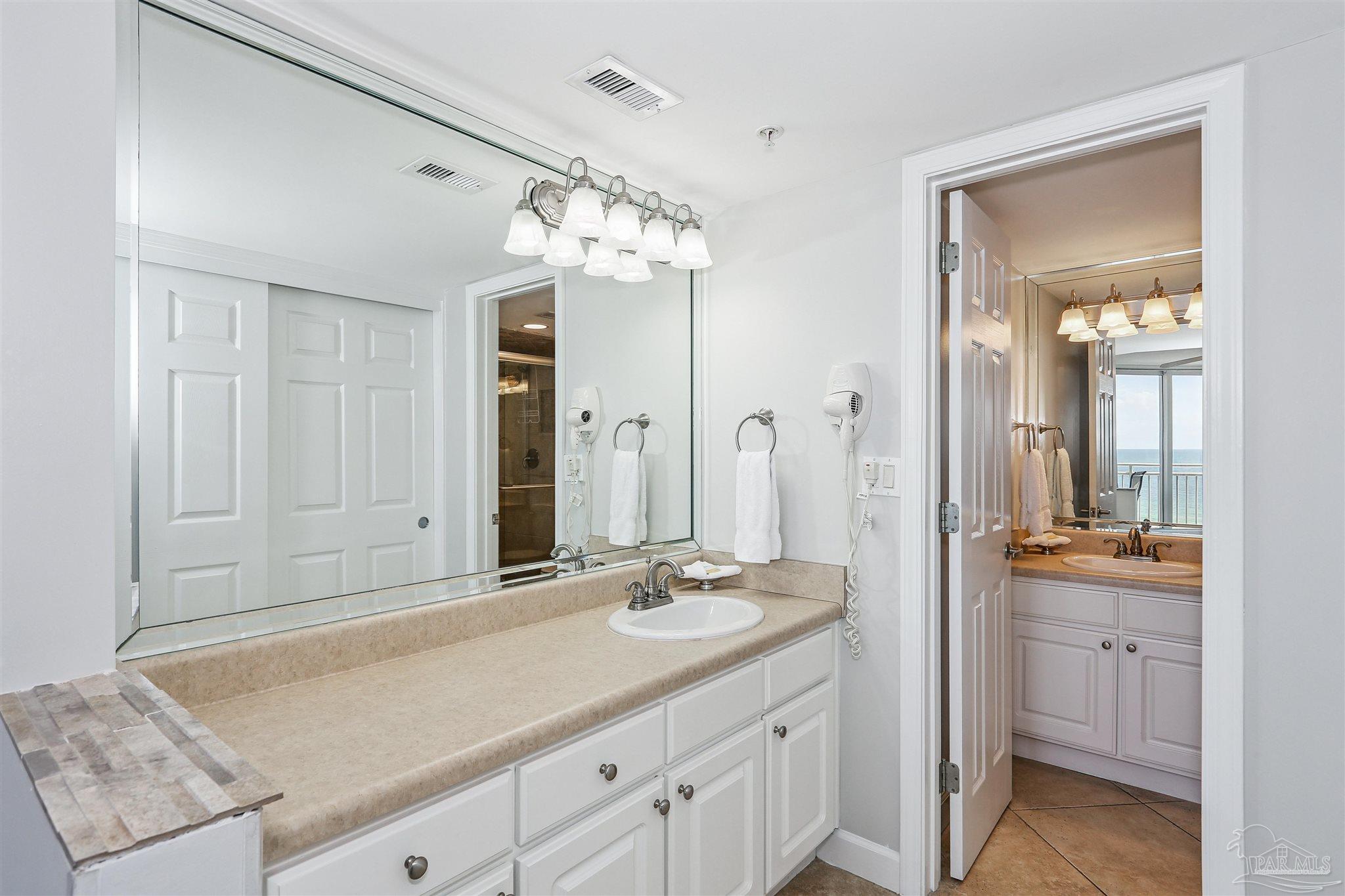 16285 Perdido Key Drive, Unit 424 Pensacola, FL 32507 - Photo 25 of 53 a spacious bathroom with a granite countertop sink a mirror and a shower