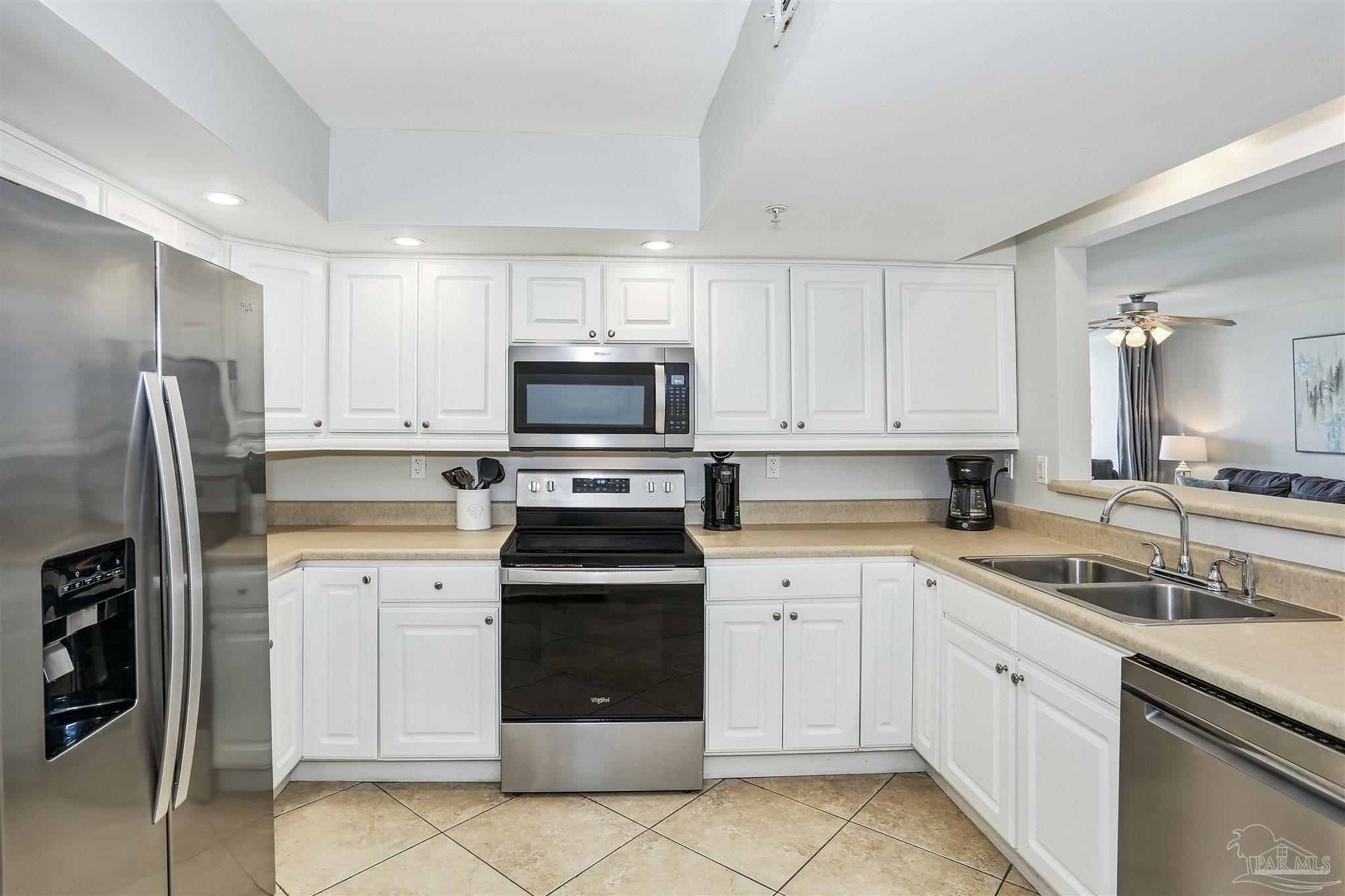 16285 Perdido Key Drive, Unit 424 Pensacola, FL 32507 - Photo 28 of 53 a kitchen with white cabinets sink and stainless steel appliances