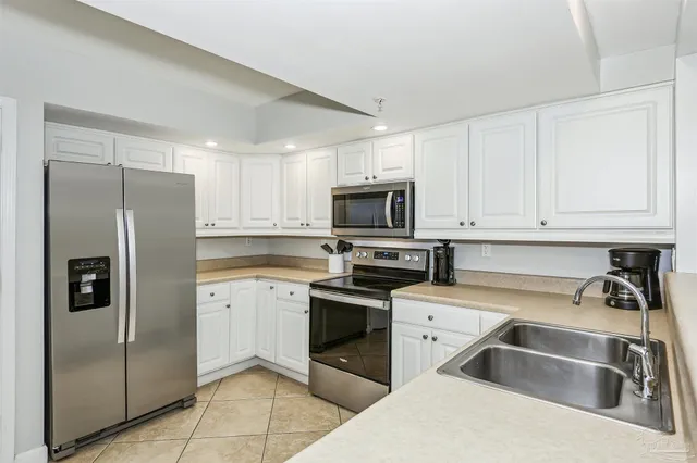 a kitchen with stainless steel appliances granite countertop a refrigerator sink and stove