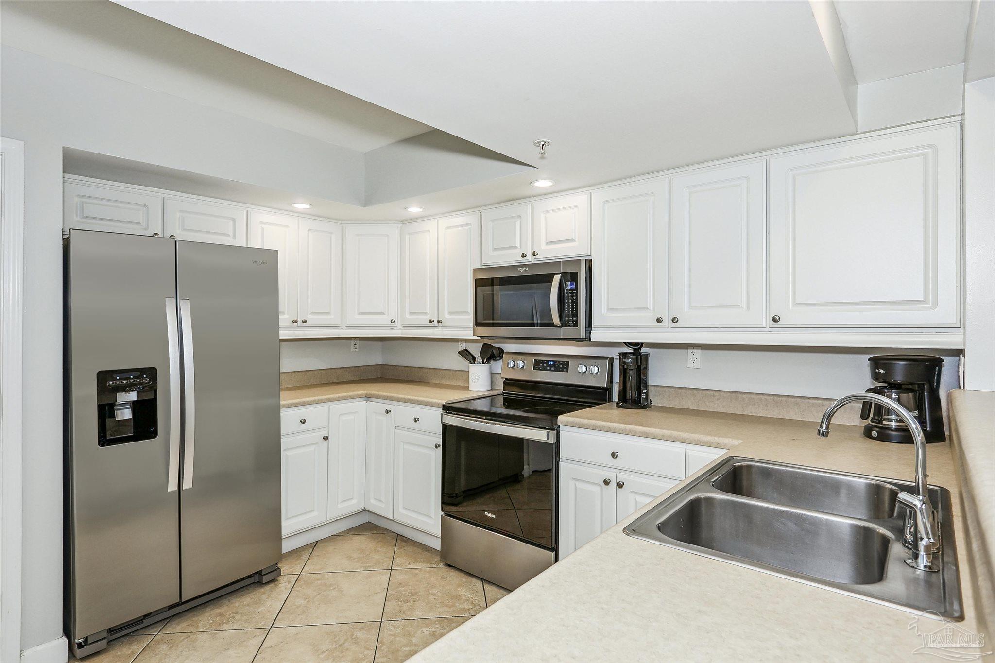 16285 Perdido Key Drive, Unit 424 Pensacola, FL 32507 - Photo 29 of 53 a kitchen with stainless steel appliances granite countertop a refrigerator sink and stove