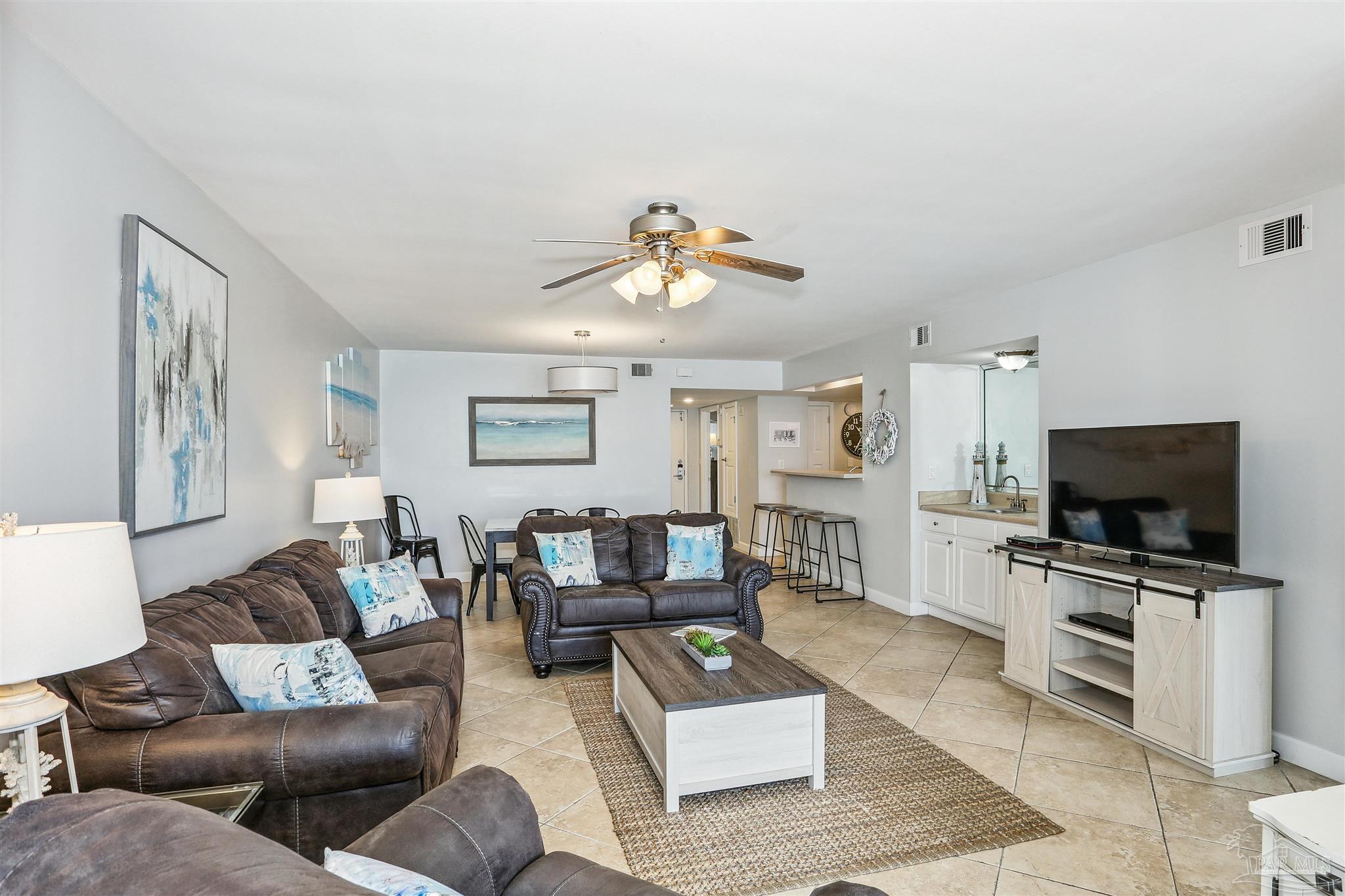 16285 Perdido Key Drive, Unit 424 Pensacola, FL 32507 - Photo 8 of 53 a living room with furniture and a flat screen tv