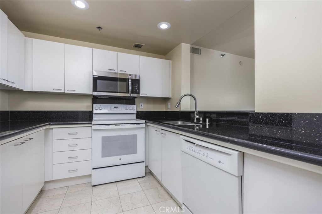 525 East Seaside Way, Unit 704 Long Beach, CA 90802 - Photo 13 of 38 a kitchen with cabinets appliances a sink and a counter top