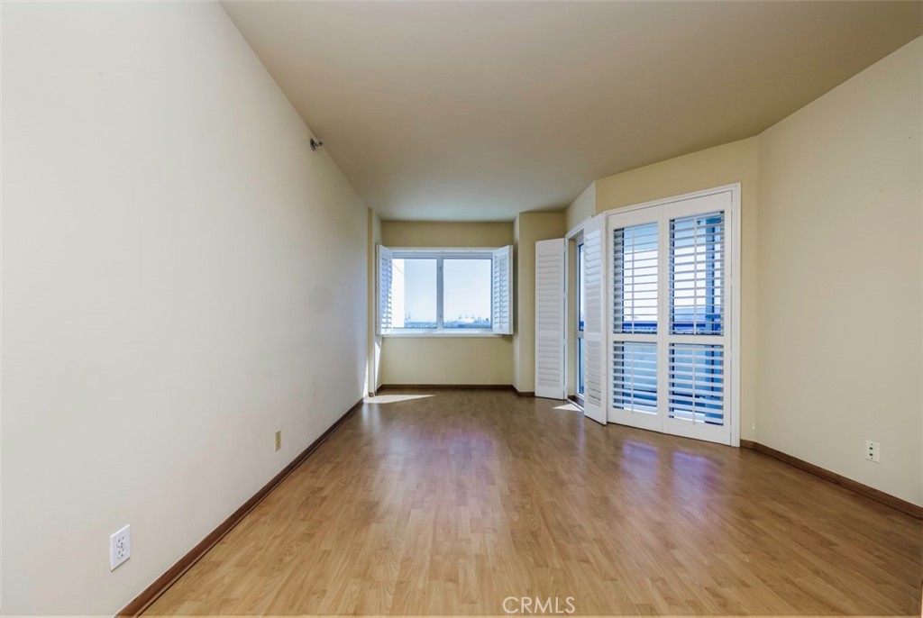 525 East Seaside Way, Unit 704 Long Beach, CA 90802 - Photo 16 of 38 an empty room with wooden floor and windows
