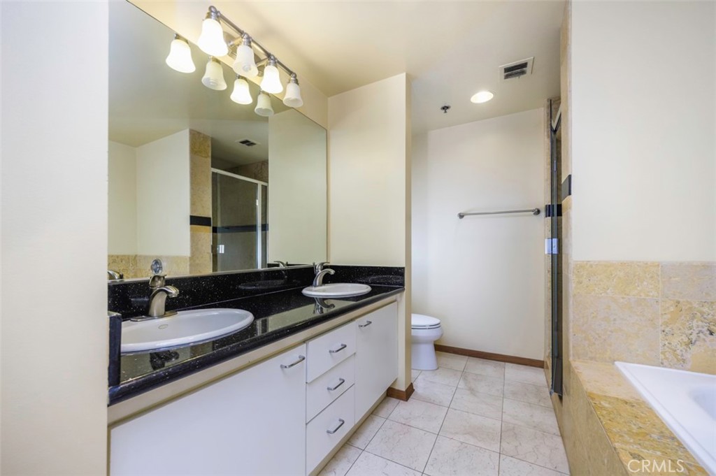 525 East Seaside Way, Unit 704 Long Beach, CA 90802 - Photo 20 of 38 a bathroom with a granite countertop sink and a mirror