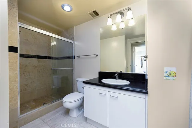 a bathroom with a granite countertop sink toilet a mirror and shower