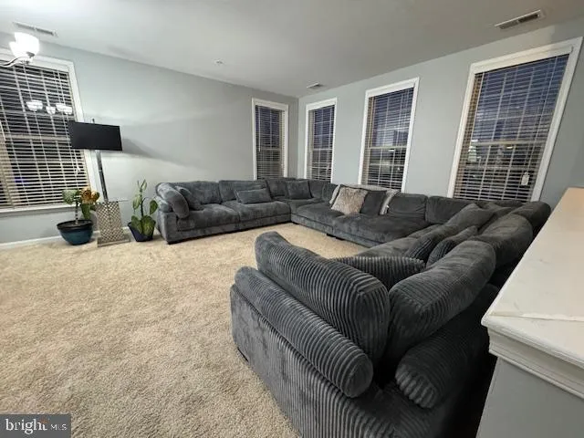 a living room with furniture a lamp and a flat screen tv