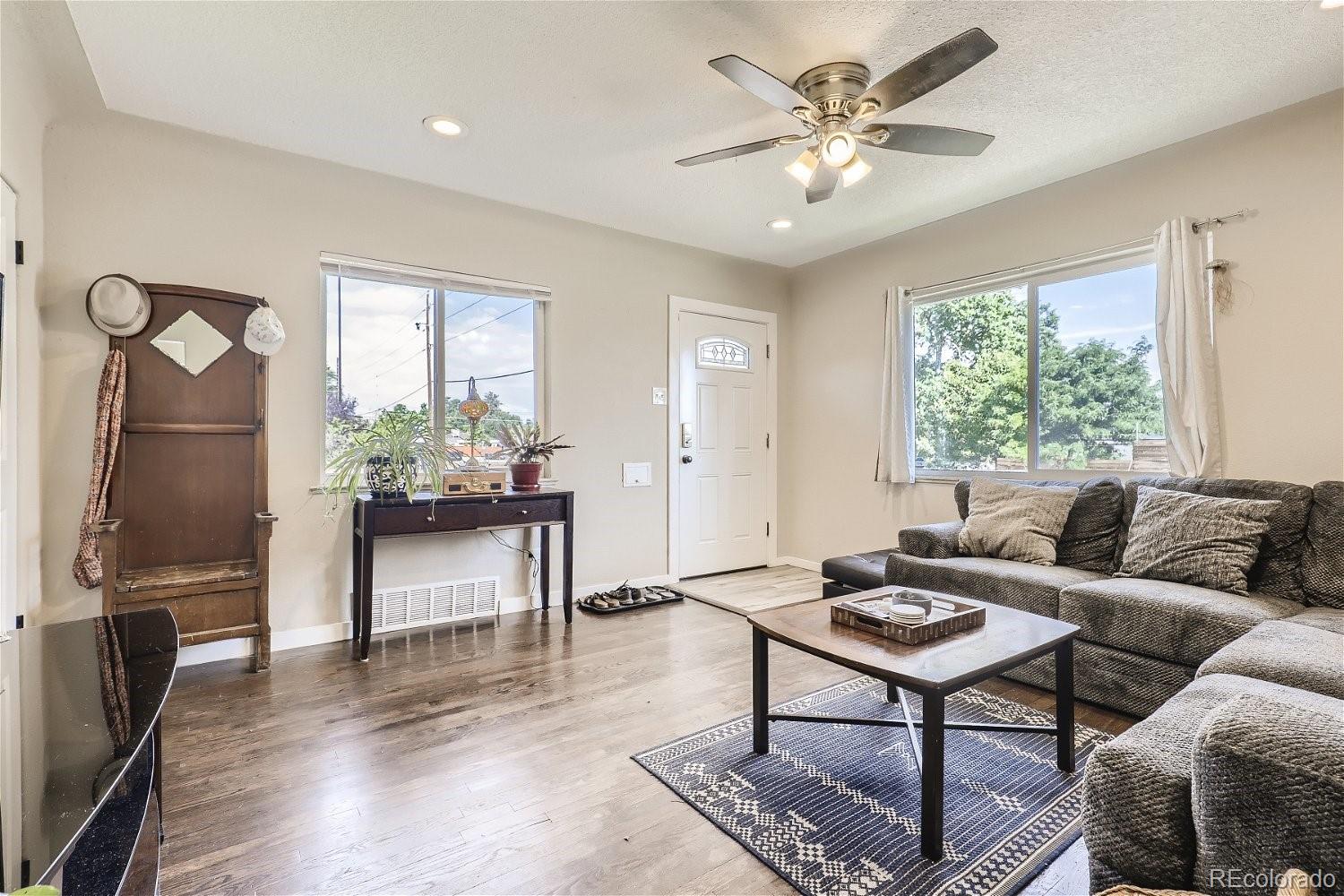 3456 Harrison Street Denver, CO 80205 - Photo 3 of 11 a living room with furniture a window and a chandelier