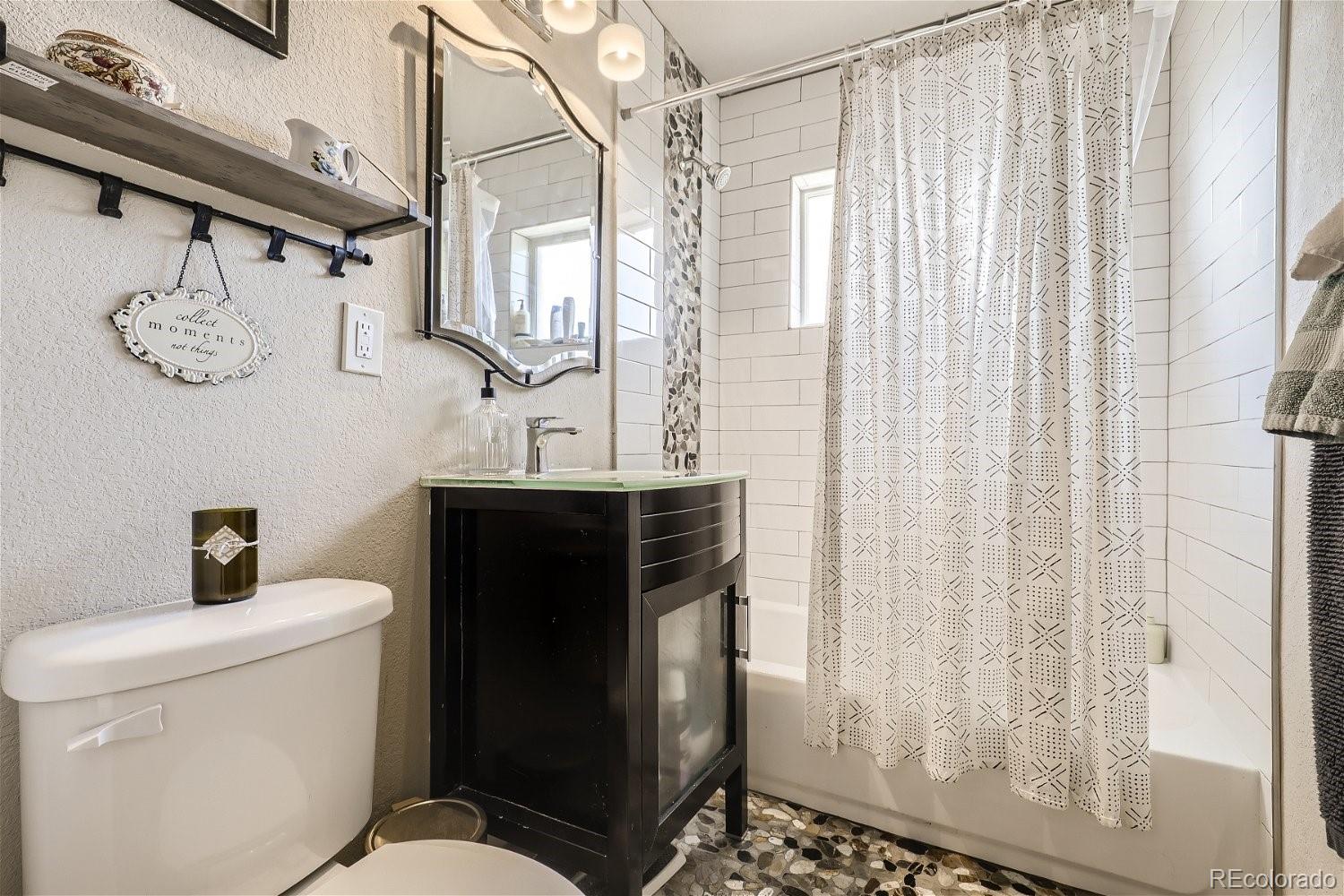 3456 Harrison Street Denver, CO 80205 - Photo 7 of 11 a bathroom with a sink toilet and shower