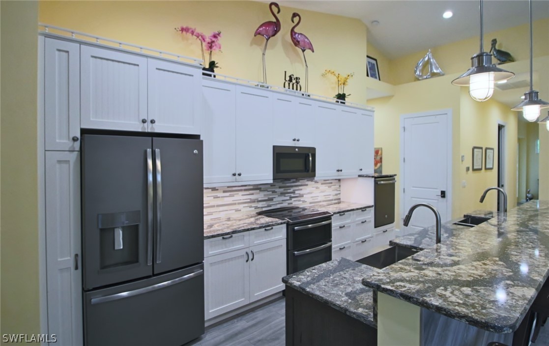 2743 Janet Street Cape Coral, FL 33993 - Photo 13 of 35 a kitchen with stainless steel appliances granite countertop a stove refrigerator and cabinets