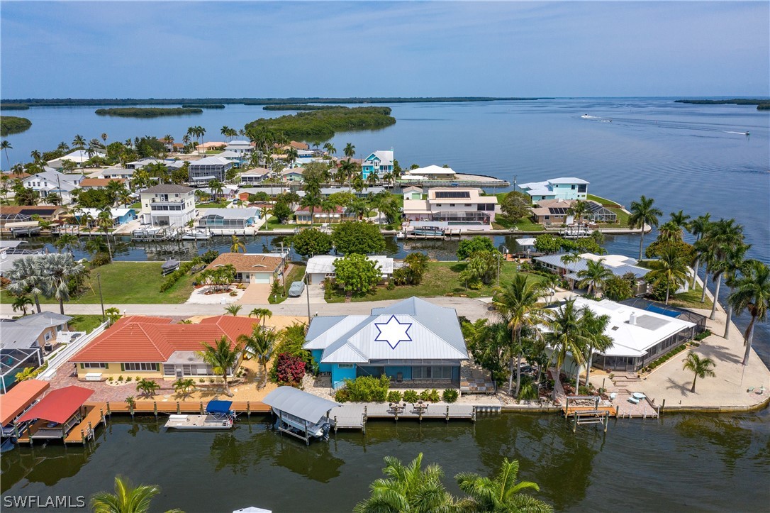 2743 Janet Street Cape Coral, FL 33993 - Photo 2 of 35 a view of a lake with boats and large trees