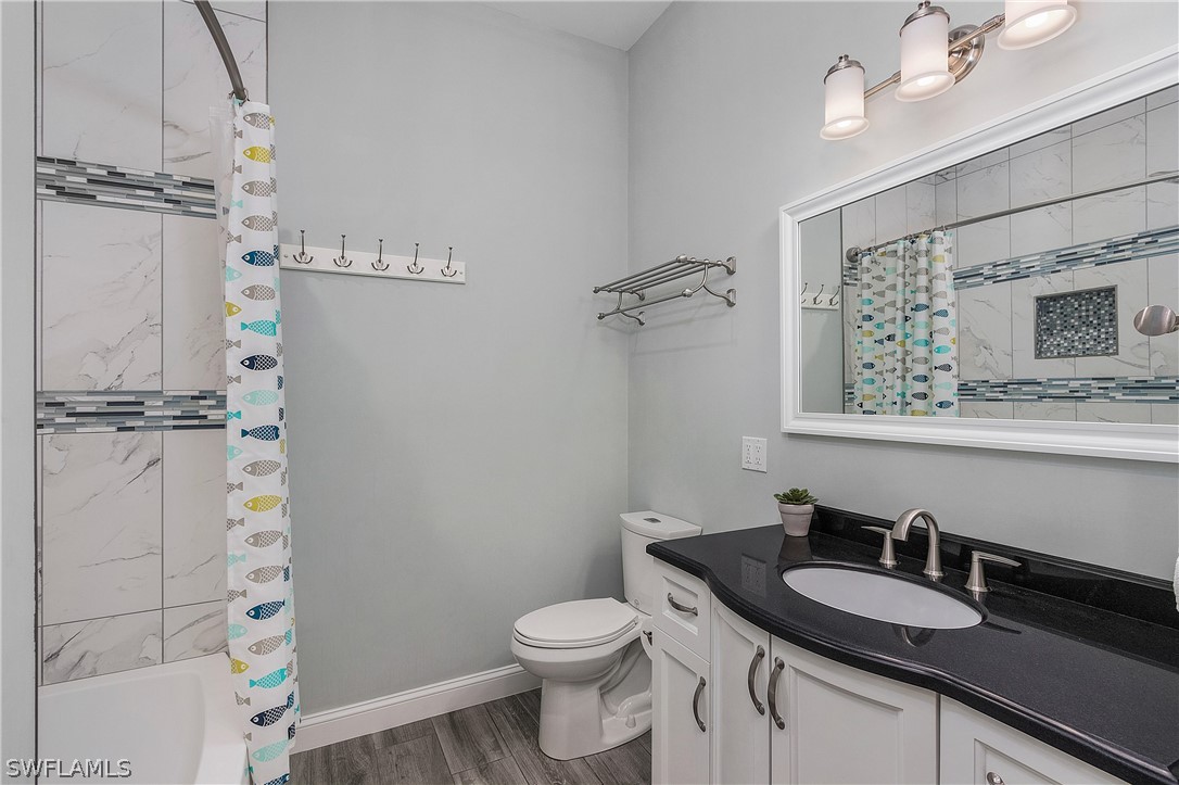 2743 Janet Street Cape Coral, FL 33993 - Photo 22 of 35 a bathroom with a granite countertop sink toilet a mirror and shower