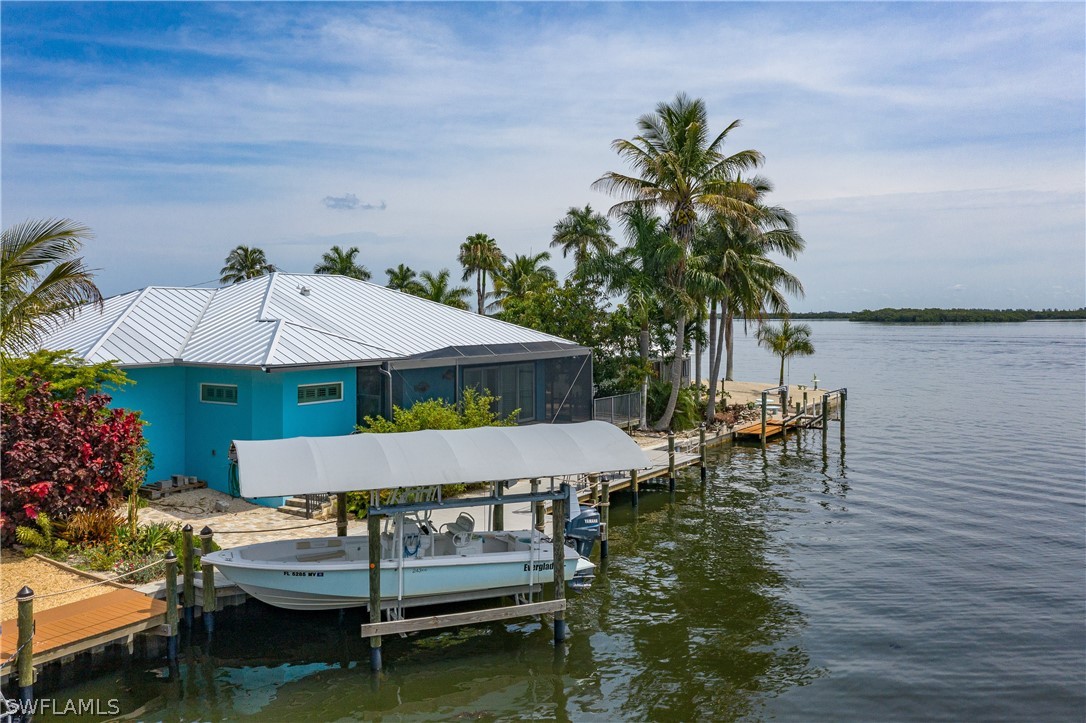 2743 Janet Street Cape Coral, FL 33993 - Photo 3 of 35 a view of a patio with table and chairs potted plants with wooden floor