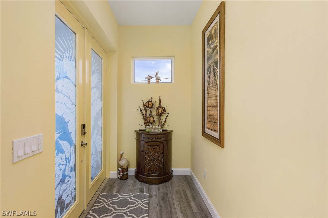 2743 Janet Street Cape Coral, FL 33993 - Photo 8 of 35 a view of a hallway with wooden floor and a potted plant