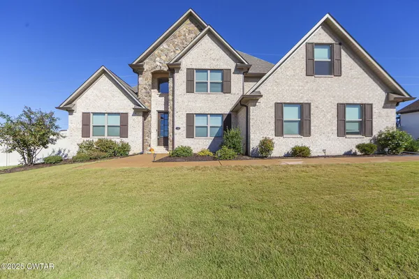 a front view of house with yard and green space