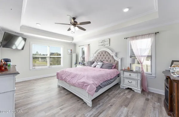 a bedroom with a bed and a flat tv screen on the dresser