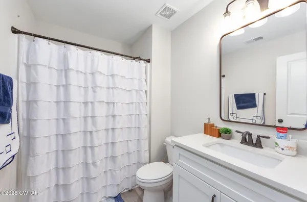 a bathroom with a sink vanity mirror and toilet