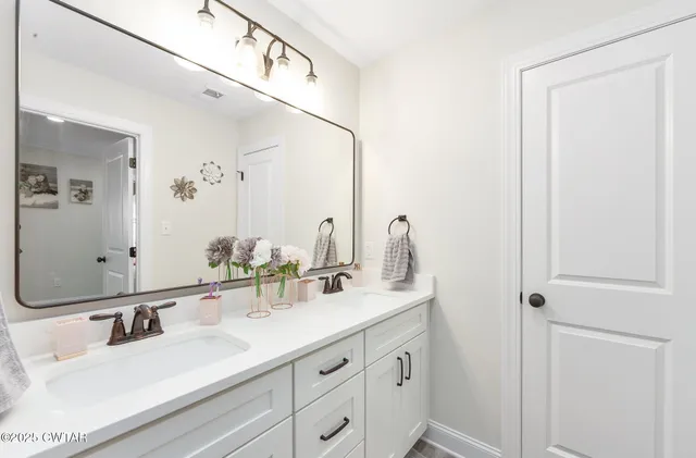 a bathroom with double vanity sink and a mirror