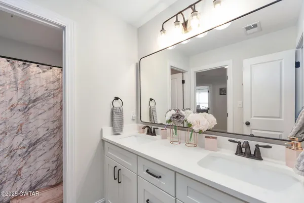 a bathroom with a double vanity sink and a mirror
