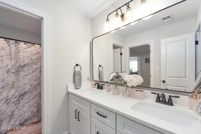 a bathroom with a double vanity sink and a mirror