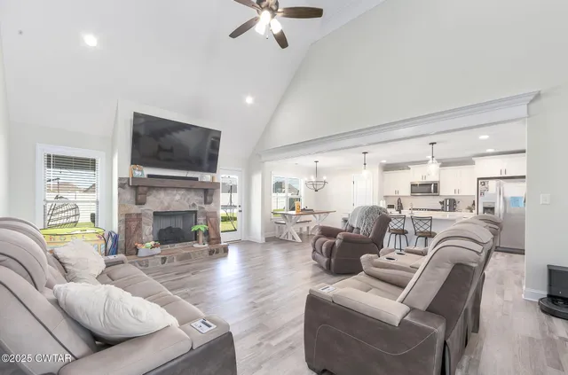 a living room with furniture a fireplace and a flat screen tv