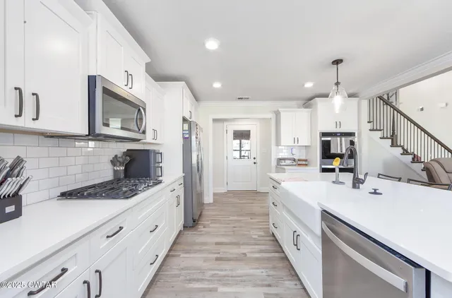a kitchen with stainless steel appliances kitchen island granite countertop a sink and cabinets