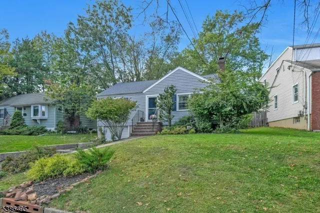 a front view of a house with a yard and trees