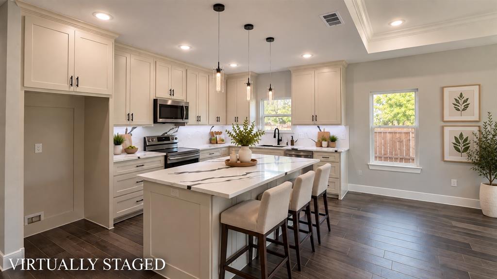 302-304 West Pine Street Whitewright, TX 75491 - Photo 8 of 38 Kitchen featuring an island with a stone-finish countertop, stainless steel appliances, recessed lighting, wood-finish flooring, and light-toned cabinetry