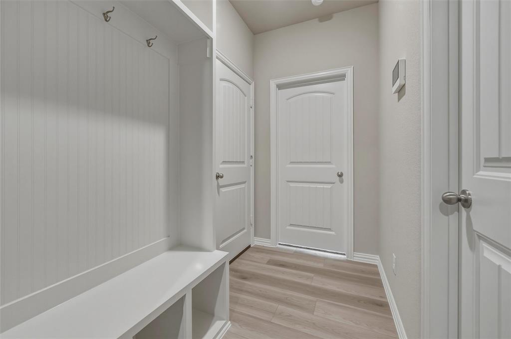 1201 Colca Drive Springtown, TX 76082 - Photo 26 of 32 Built-in storage bench with cubbies, beadboard paneling, and brushed nickel hooks