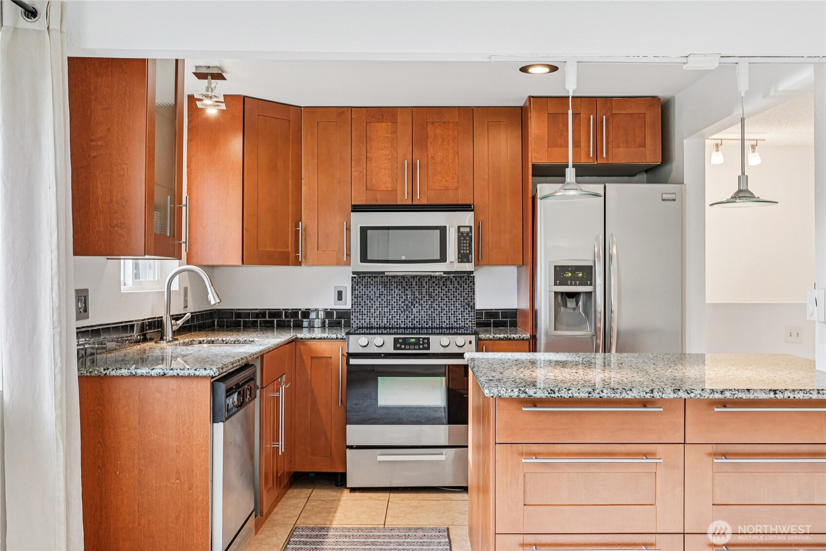 7909 218th Street Southwest, Unit 4 Edmonds, WA 98026 - Photo 11 of 29 a kitchen with stainless steel appliances granite countertop a stove a sink and a refrigerator