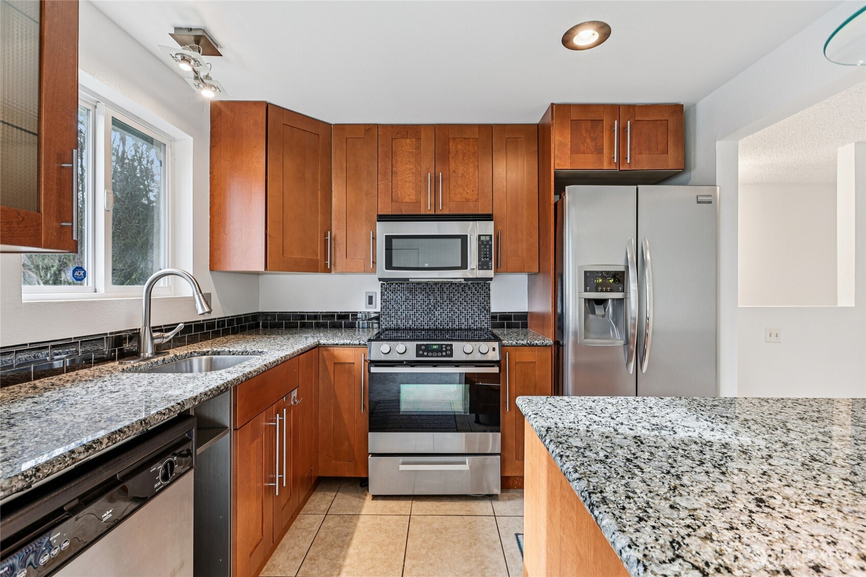 7909 218th Street Southwest, Unit 4 Edmonds, WA 98026 - Photo 13 of 29 a kitchen with stainless steel appliances granite countertop a sink stove and refrigerator