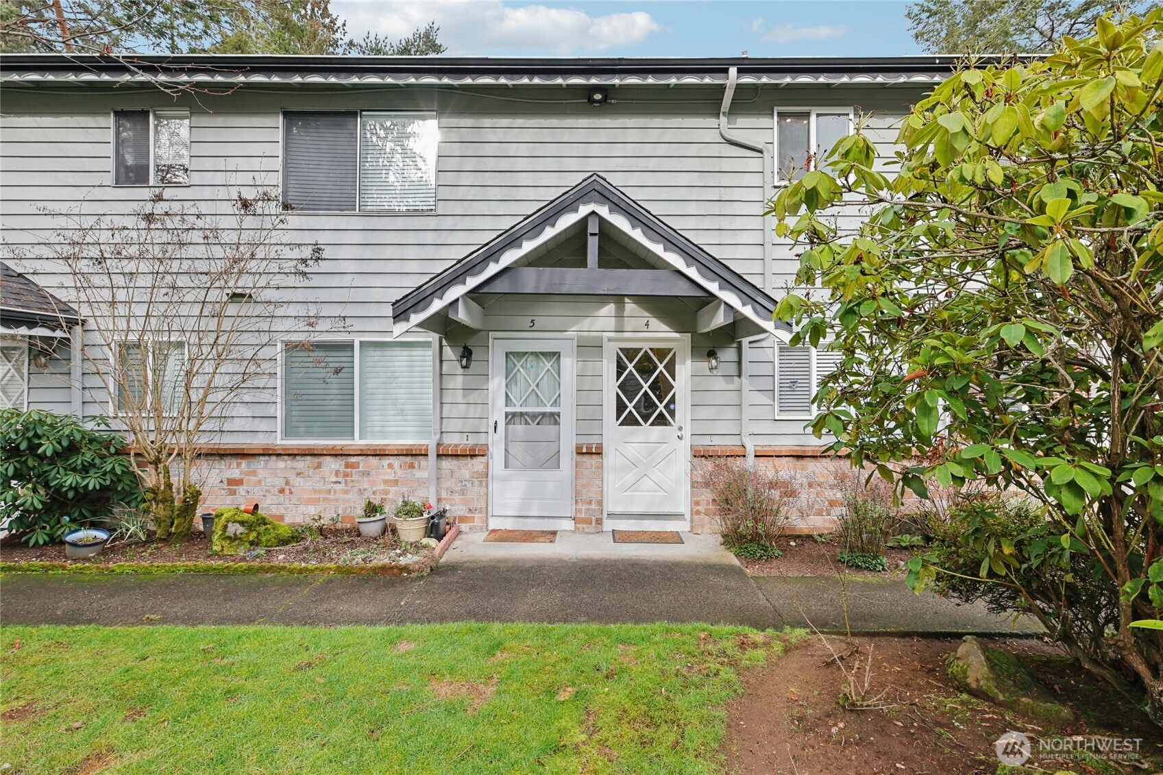 7909 218th Street Southwest, Unit 4 Edmonds, WA 98026 - Photo 2 of 29 a front view of a house with a yard and garage