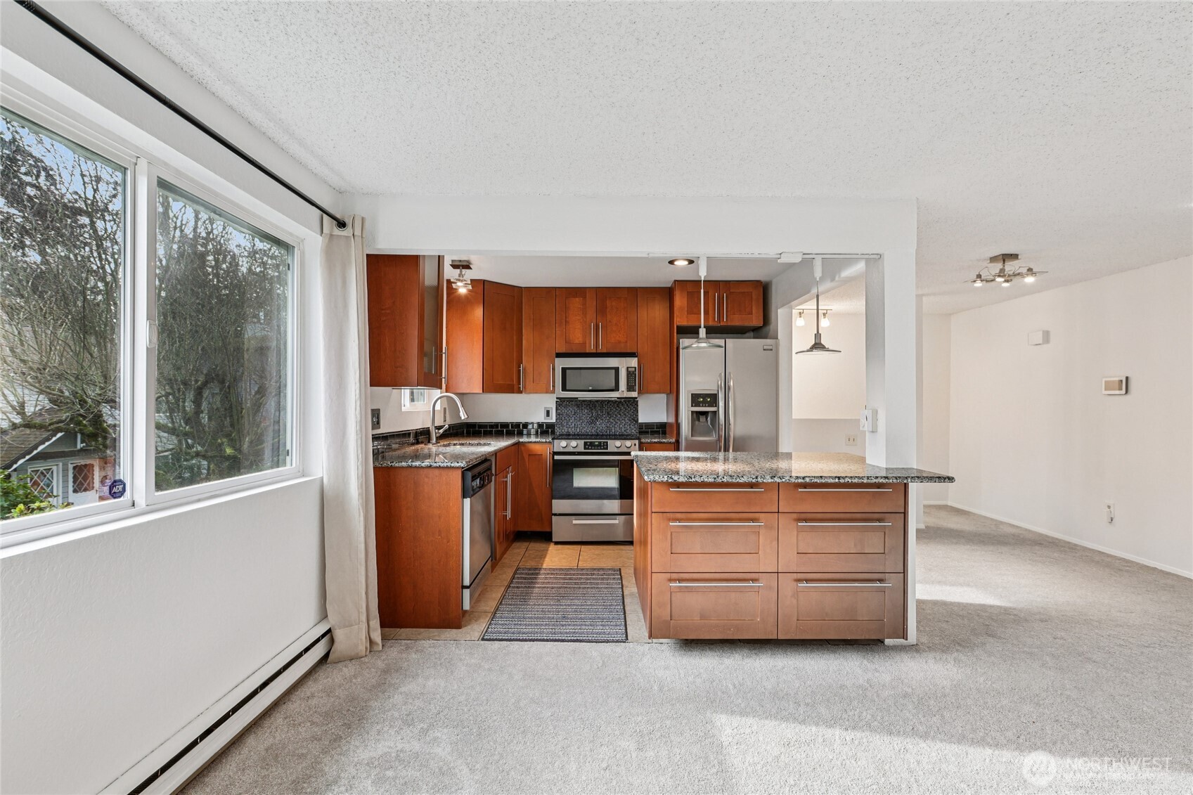 7909 218th Street Southwest, Unit 4 Edmonds, WA 98026 - Photo 9 of 29 a large kitchen with stainless steel appliances granite countertop a stove a sink and a refrigerator
