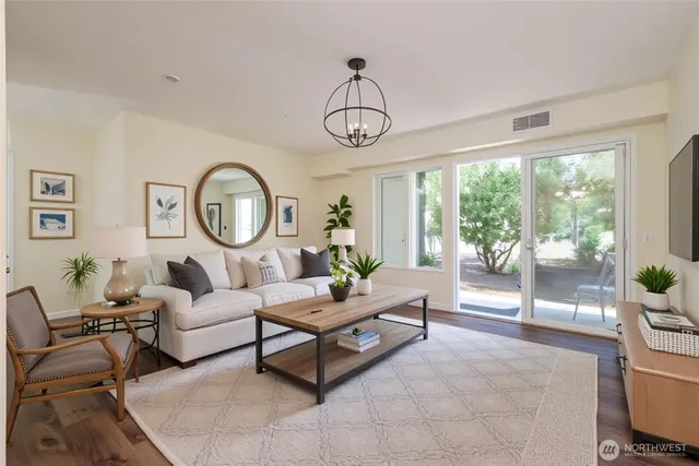 a living room with furniture a clock and a large window