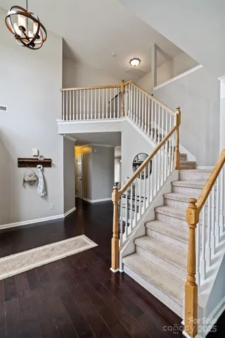 a view of a hallway with wooden floor and staircase
