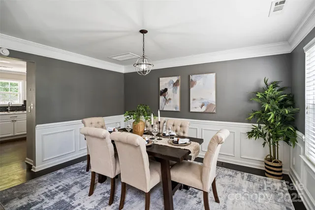 a dining room with furniture potted plants and wooden floor