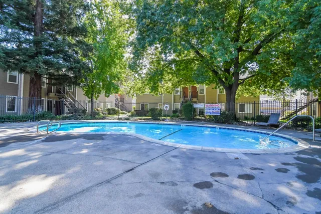 a view of a swimming pool and trees in the background